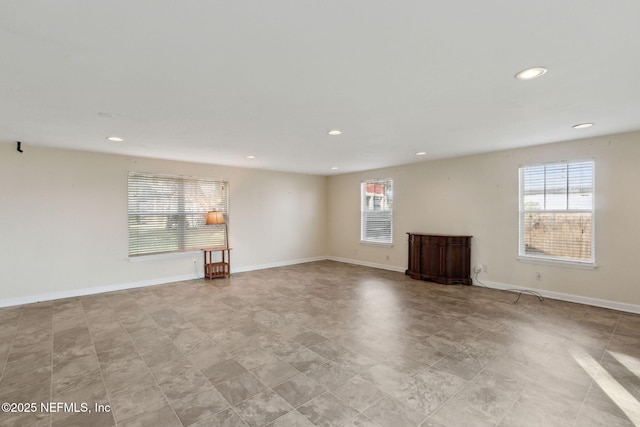 spare room featuring plenty of natural light, baseboards, and recessed lighting