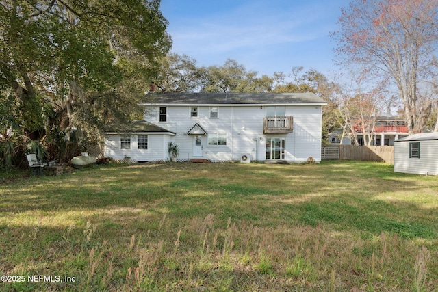 back of house with a lawn and fence