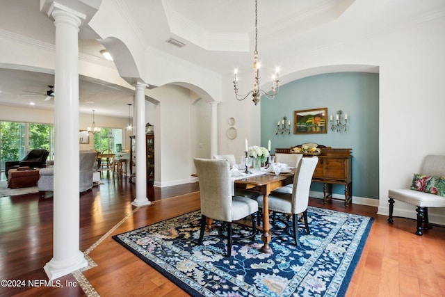 dining area featuring hardwood / wood-style floors, ceiling fan with notable chandelier, ornamental molding, and a tray ceiling