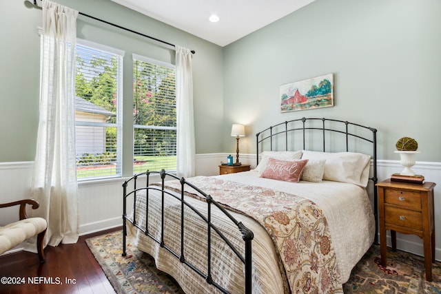 bedroom with dark hardwood / wood-style flooring and multiple windows