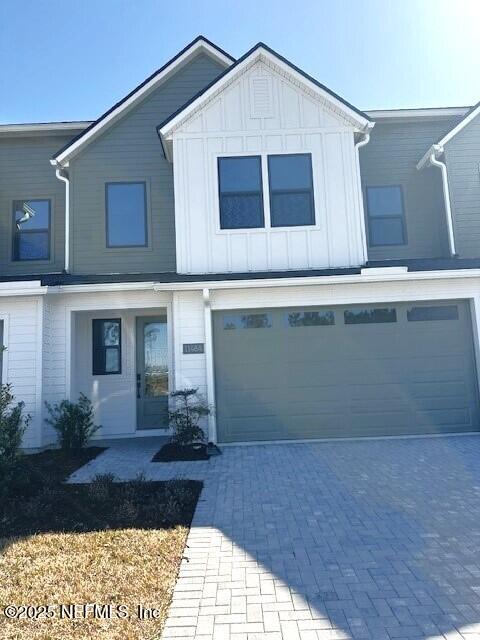 view of front of home with a garage, decorative driveway, and board and batten siding