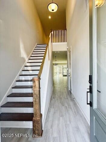 staircase featuring a high ceiling and wood finished floors