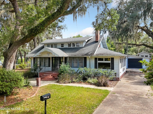 view of front of house with a garage, covered porch, and a front lawn