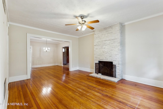 unfurnished living room featuring hardwood / wood-style flooring, crown molding, a brick fireplace, and a textured ceiling