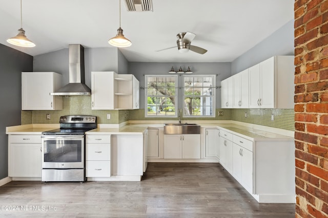 kitchen featuring white cabinets, electric range, sink, and wall chimney range hood