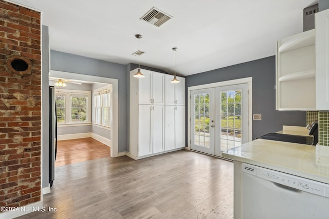 kitchen featuring decorative light fixtures, white cabinets, light hardwood / wood-style floors, white dishwasher, and french doors