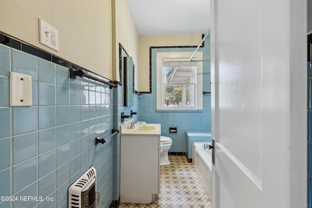 bathroom featuring tile walls, vanity, a tub to relax in, tile patterned floors, and toilet