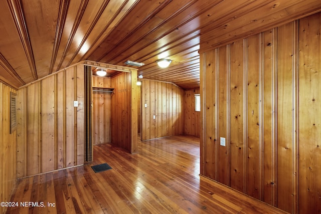 additional living space featuring wood-type flooring, lofted ceiling, wooden walls, and wood ceiling