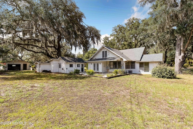 view of front of home with a garage, central AC, and a front lawn