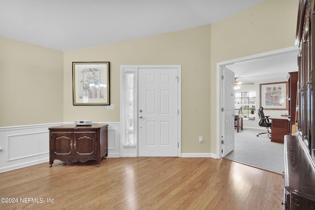 foyer featuring light wood-type flooring, vaulted ceiling, and ceiling fan