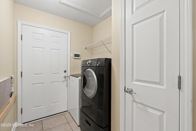 laundry area with a textured ceiling and light tile patterned floors