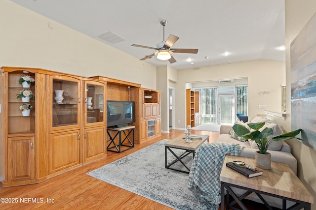 living room with ceiling fan, lofted ceiling, and light hardwood / wood-style flooring