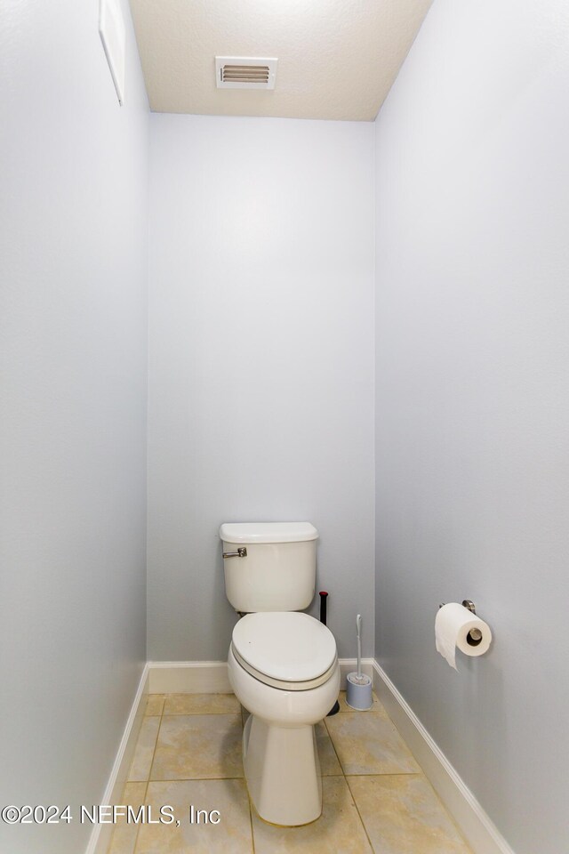 bathroom with tile patterned flooring and toilet