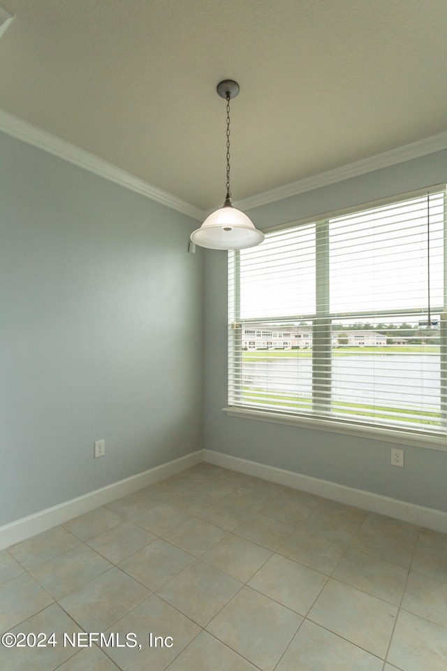 tiled empty room featuring crown molding