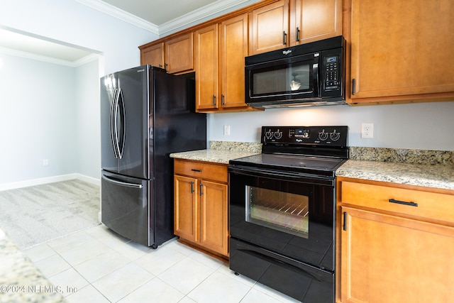 kitchen with crown molding, black appliances, light tile patterned floors, and light stone countertops