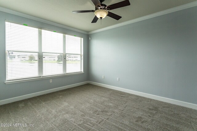 empty room featuring ornamental molding, ceiling fan, and carpet floors