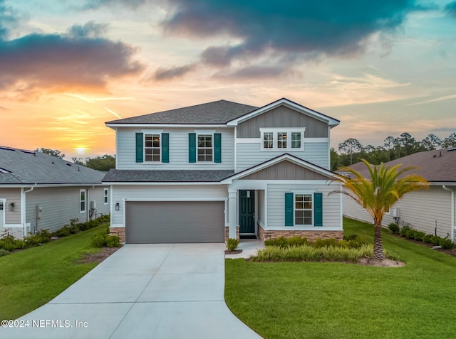 craftsman inspired home with a garage and a lawn