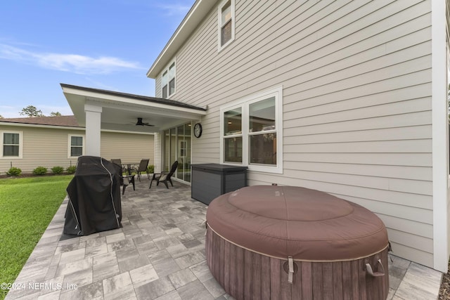 view of patio with area for grilling, a hot tub, and ceiling fan