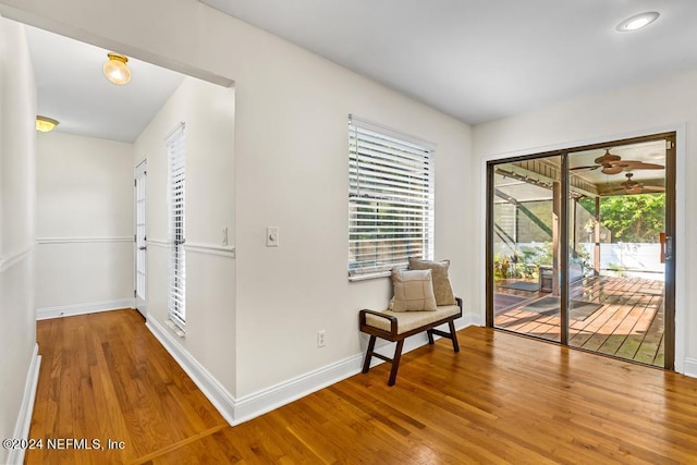 living area with hardwood / wood-style flooring and ceiling fan