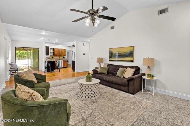 living room featuring ceiling fan, lofted ceiling, and light colored carpet