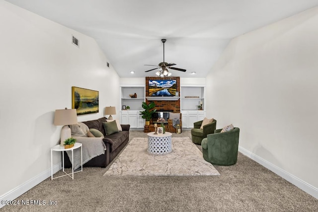 carpeted living room with lofted ceiling, a brick fireplace, built in features, and ceiling fan