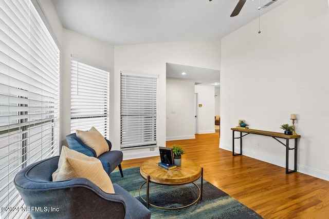 living area featuring hardwood / wood-style flooring, lofted ceiling, and ceiling fan