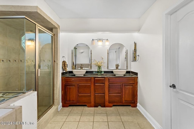 bathroom with tile patterned flooring, vanity, and a shower with shower door