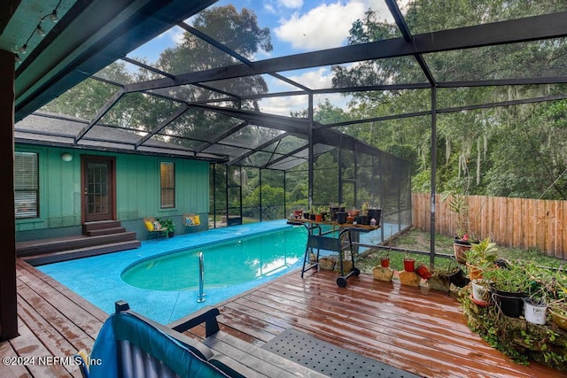 view of swimming pool featuring glass enclosure