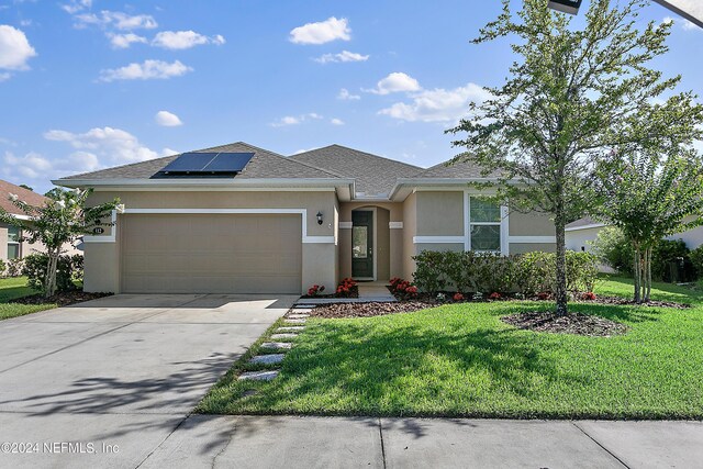 prairie-style house featuring a front lawn, solar panels, and a garage