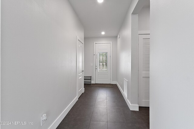 doorway featuring dark tile patterned floors