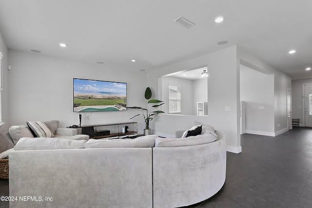 living area with baseboards, visible vents, and recessed lighting