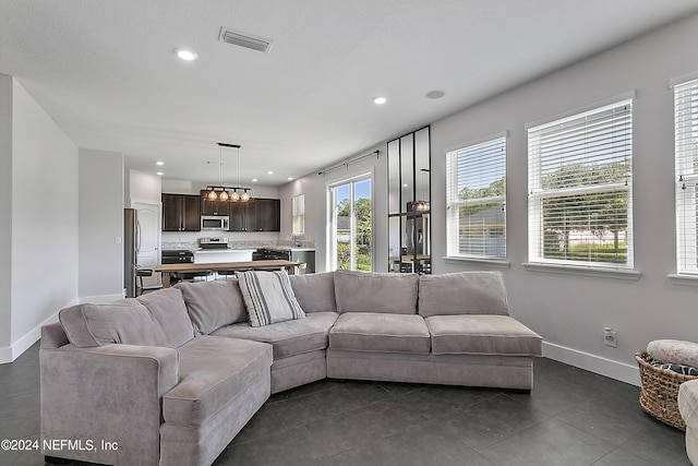 living room featuring baseboards, visible vents, and recessed lighting