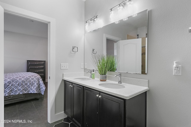 bathroom featuring double vanity, ensuite bath, a sink, and tile patterned floors