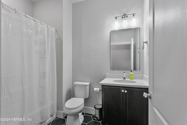 full bathroom featuring tile patterned flooring, toilet, a shower with shower curtain, vanity, and baseboards