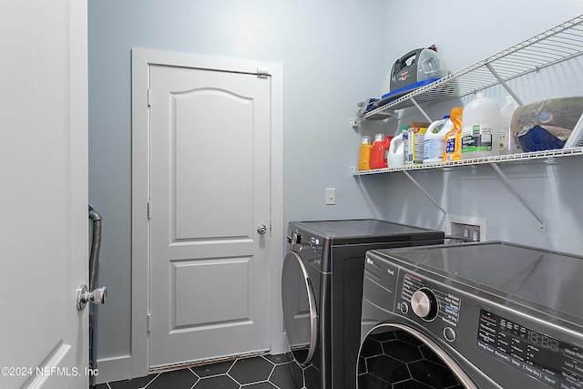 washroom featuring laundry area, dark tile patterned floors, and washing machine and dryer