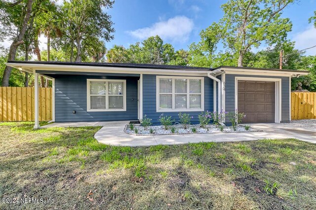 ranch-style house featuring a garage and a front lawn