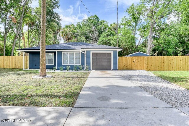 single story home featuring a front lawn and a garage