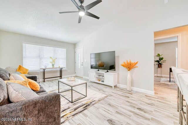 living room with lofted ceiling, ceiling fan, and light hardwood / wood-style floors