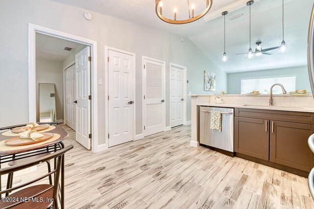 kitchen featuring sink, light wood-type flooring, decorative light fixtures, and stainless steel dishwasher