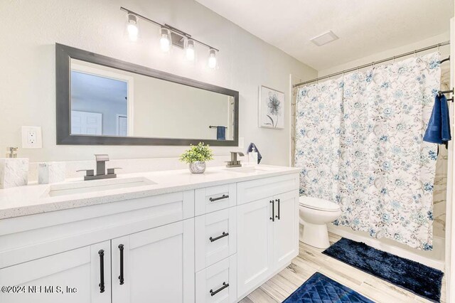 bathroom with toilet, curtained shower, wood-type flooring, and vanity