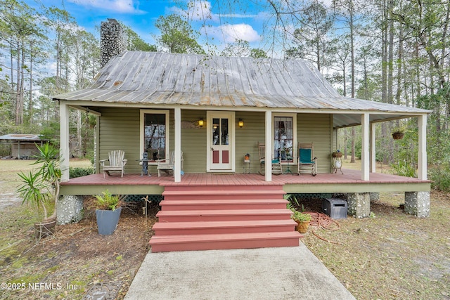 farmhouse featuring a porch and metal roof