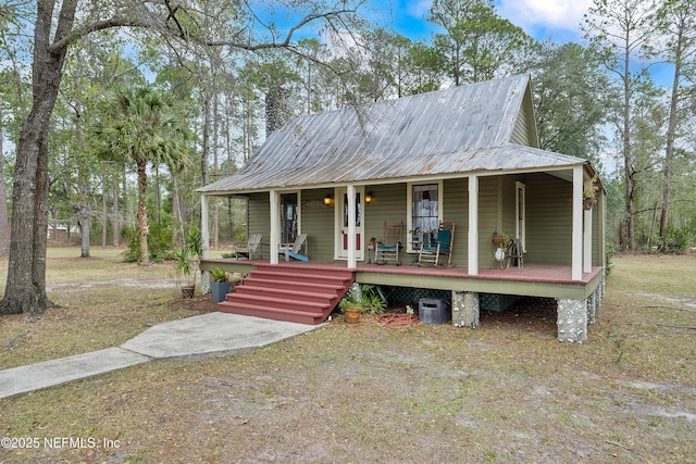 country-style home with a porch and metal roof