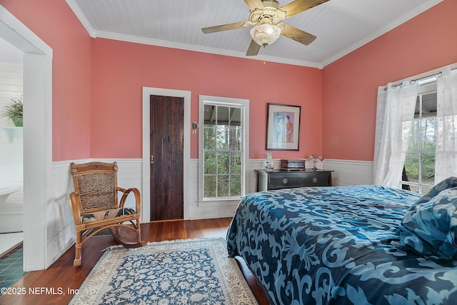 bedroom with ornamental molding, wainscoting, wood finished floors, and a ceiling fan