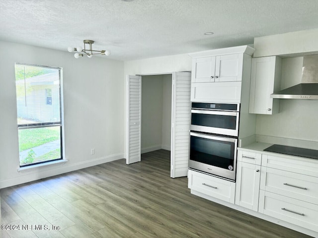 kitchen with dark wood-type flooring, white cabinets, double oven, and black electric cooktop