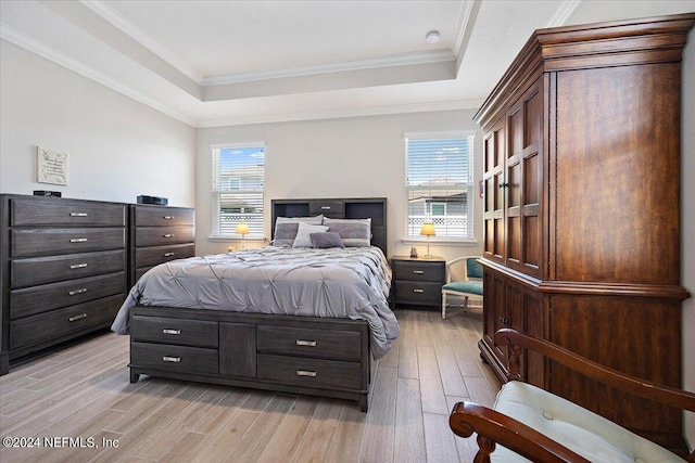 bedroom featuring light wood-type flooring, a raised ceiling, multiple windows, and crown molding