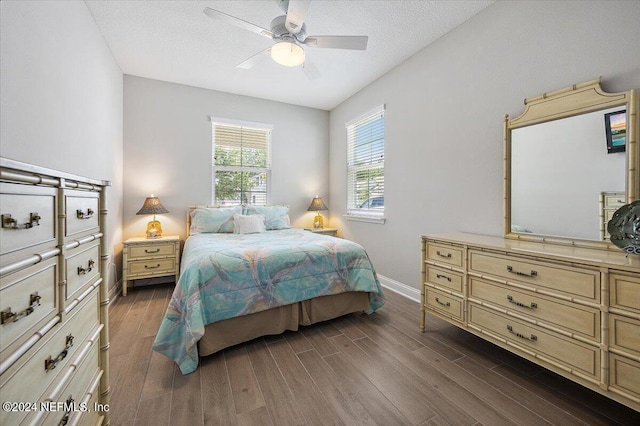 bedroom featuring ceiling fan, dark hardwood / wood-style flooring, and a textured ceiling