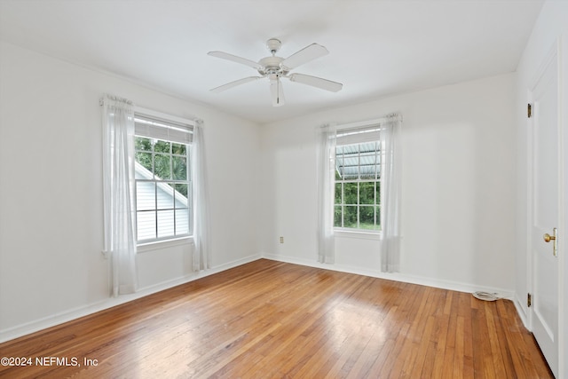 spare room featuring a healthy amount of sunlight, hardwood / wood-style floors, and ceiling fan