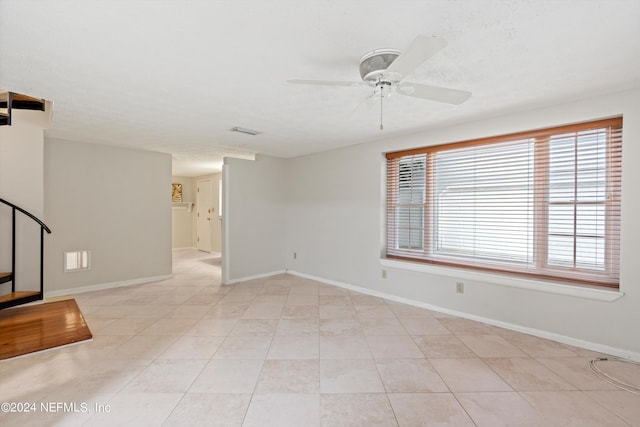 empty room with light tile patterned floors and ceiling fan