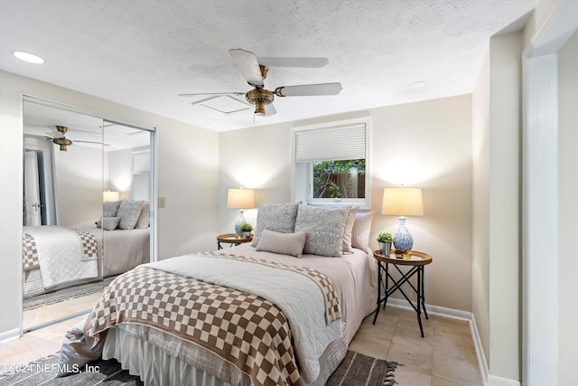 tiled bedroom with a textured ceiling, a closet, and ceiling fan