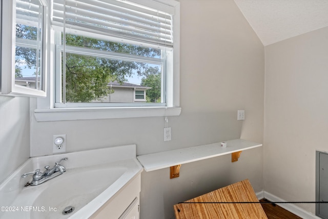 bathroom featuring lofted ceiling, vanity, plenty of natural light, and a textured ceiling